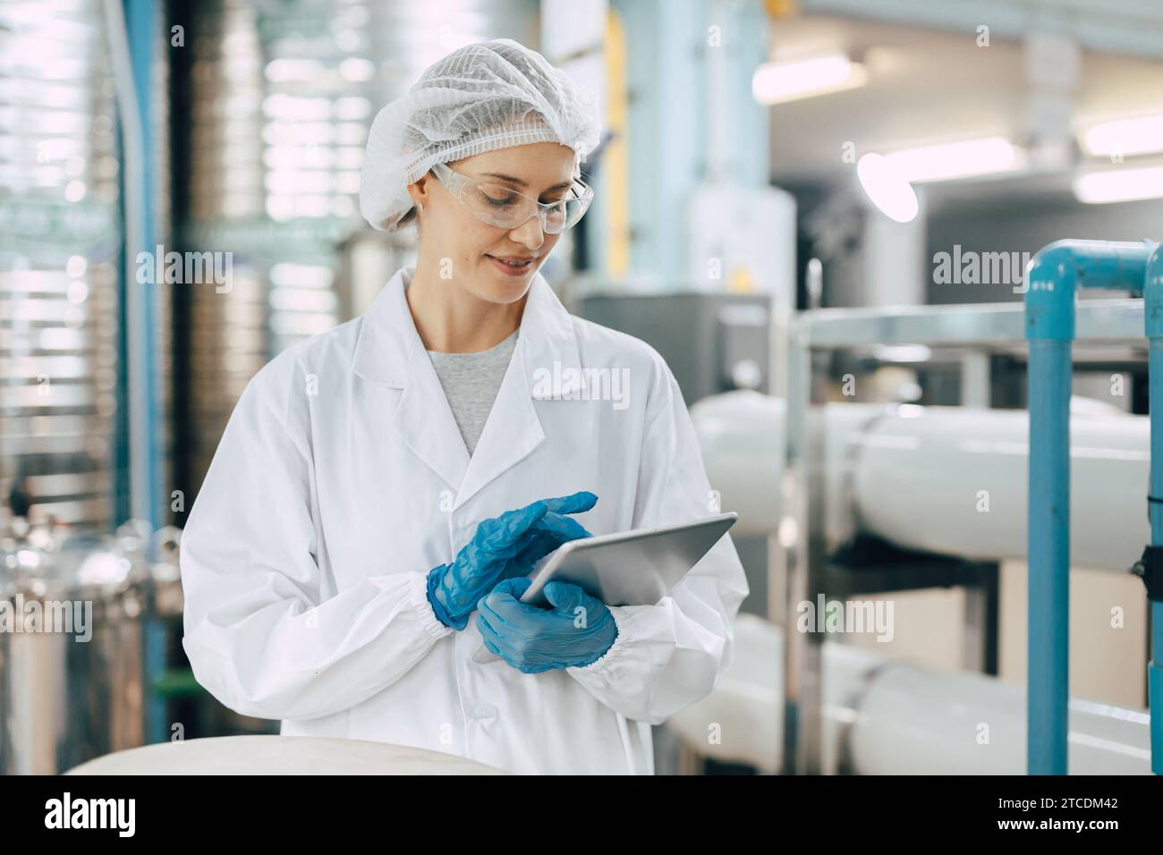 Glückliche hochrangige wissenschaftliche Mitarbeiter weibliche Arbeitskräfte kontrollieren die Wasserqualität in der Trinkwasseranlage mit Tablets, um Jobs aufzuzeichnen. Stockfoto