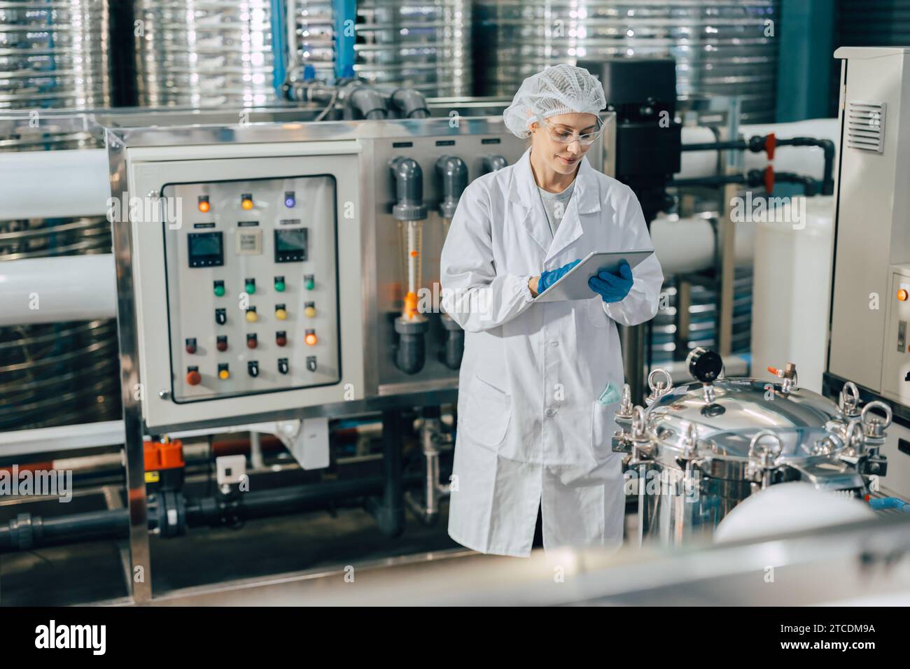 Hygienepersonal in der Lebensmittel- und Getränkefabrik. Arbeitende Frauen in der Wasserkraftwerksindustrie Qualitätskontrolle. Stockfoto