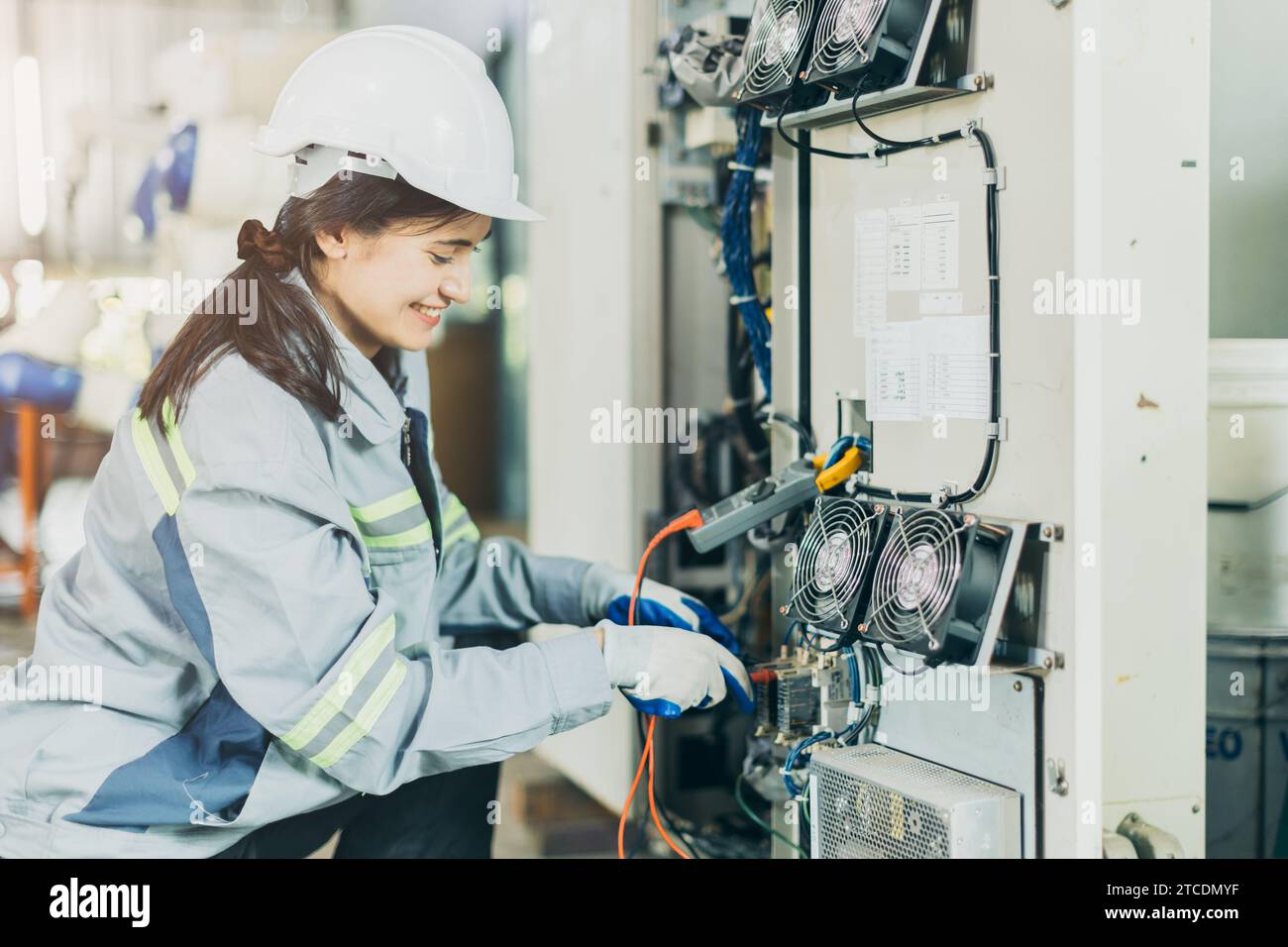 Elektriker Frauen Arbeiter Überprüfung Reparatur Wartung Wartung Wartung Wartung elektrische Anlage reparieren. Weibliche Elektroingenieurin, die Elektrokabel am Hauptstromnetz testet Stockfoto