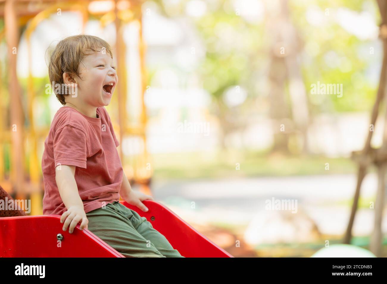 Fröhlicher, verspielter Junge, lustig, lachend, lächelndes Kind, genießen Sie die Aktivität auf dem Spielplatz im Freien im Sommer. Stockfoto