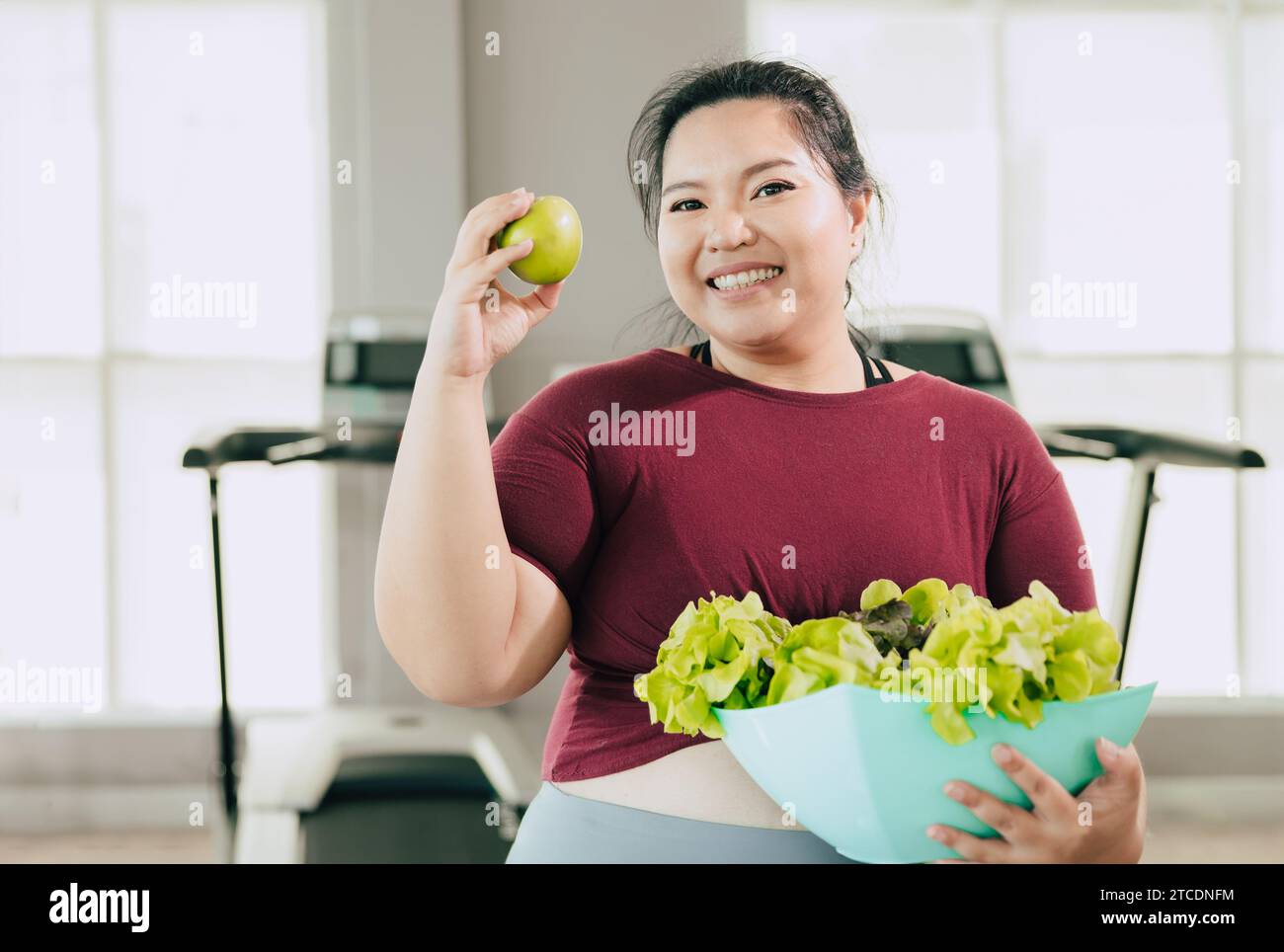 Fette Frauen glücklich genießen es, grünen Salat Gemüse und Apfelfrucht für Vitamin Gesundheit Diät Detox und Bewegung Aktivität für Gewichtsverlust zu essen. Stockfoto