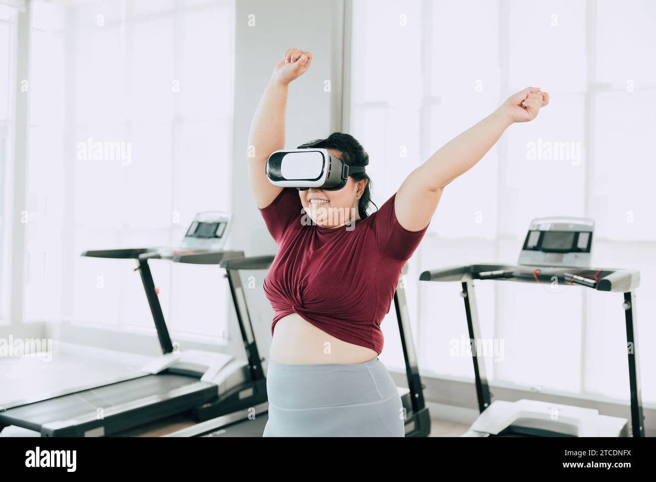 Frauen in Übergröße, die VR-Headset verwenden, genießen visuelle Sport-Fitness-Spielübungen. Menschen, die moderne Technik für das Heilbehandlungskonzept nutzen. Stockfoto