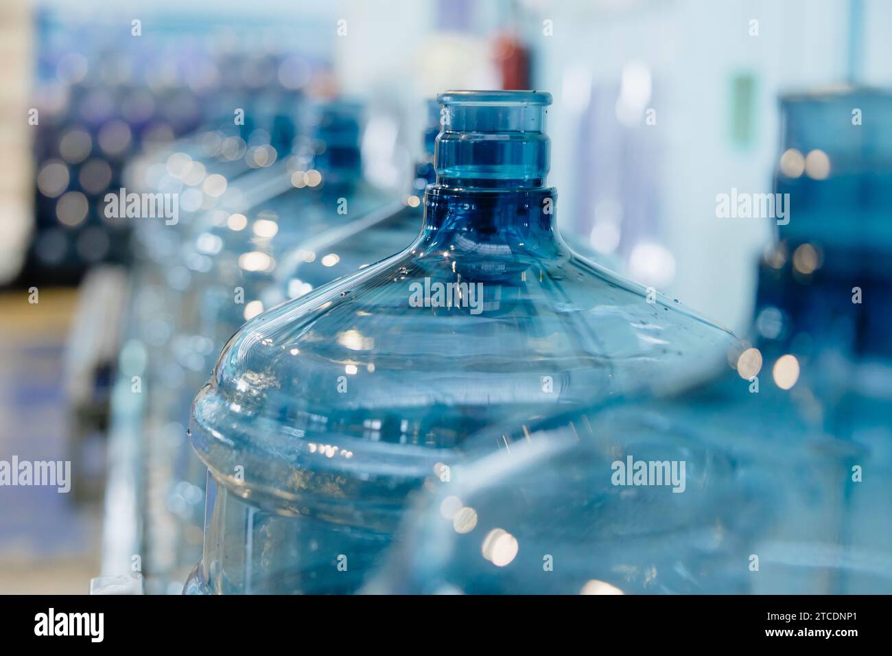 PET-Trinkwasser-Gallonenflasche aus Kunststoff sauber in der Förderband-Produktionslinie in der Trinkwasserfabrik. Stockfoto