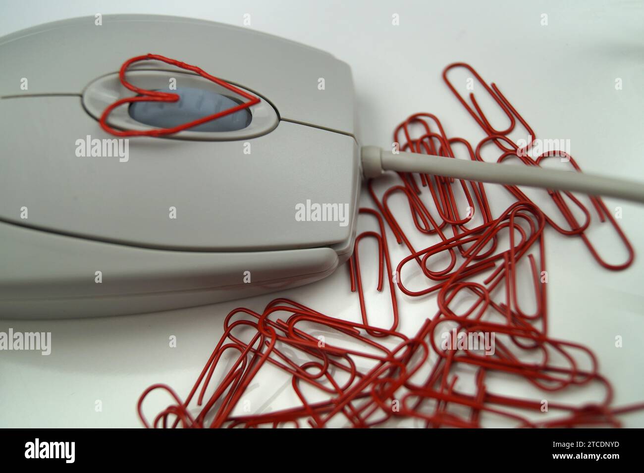 Computermaus mit roten Büroklammern, eine davon herzförmig, liebt das Büro Stockfoto