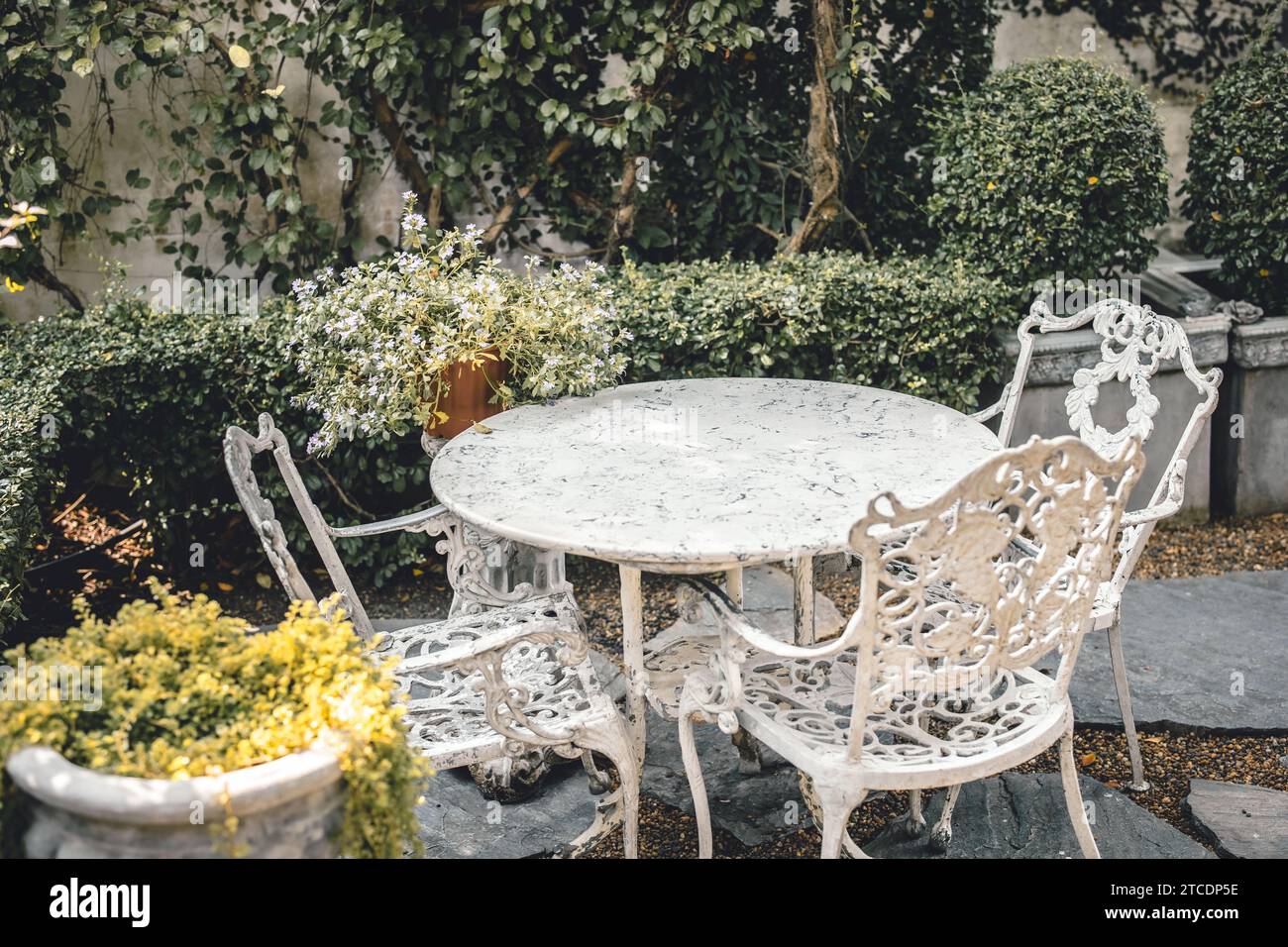 Klassischer Tisch im Garten. Vintage luxuriöser viktorianischer Stil Mable Stone Tischstuhl im Outdoor Gothic Garten Hinterhof Sommersaison. Stockfoto