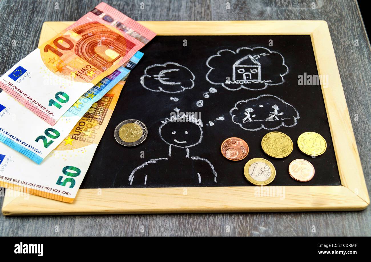 Ein Mann mit Gedankenblase, der "Euro, Haus, Kinder" auf ein Schiefer wirft, symbolisches Bild für den Aufbau von Kindergeld Stockfoto