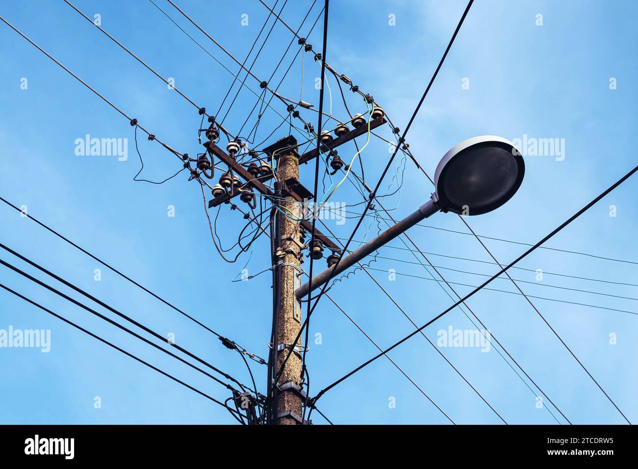 Straßenleuchte mit Stromanschluss und unordentlichen elektrischen Drähten, geringer Blickwinkel Stockfoto