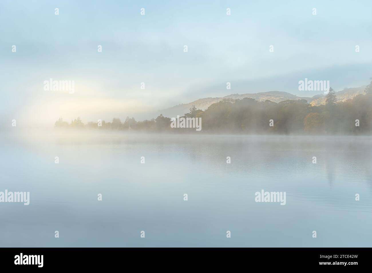 Neblige herbstliche Reflexionen am frühen Morgen auf dem Wasser von Coniston, das vom Kopf des Sees aufgenommen wurde Stockfoto