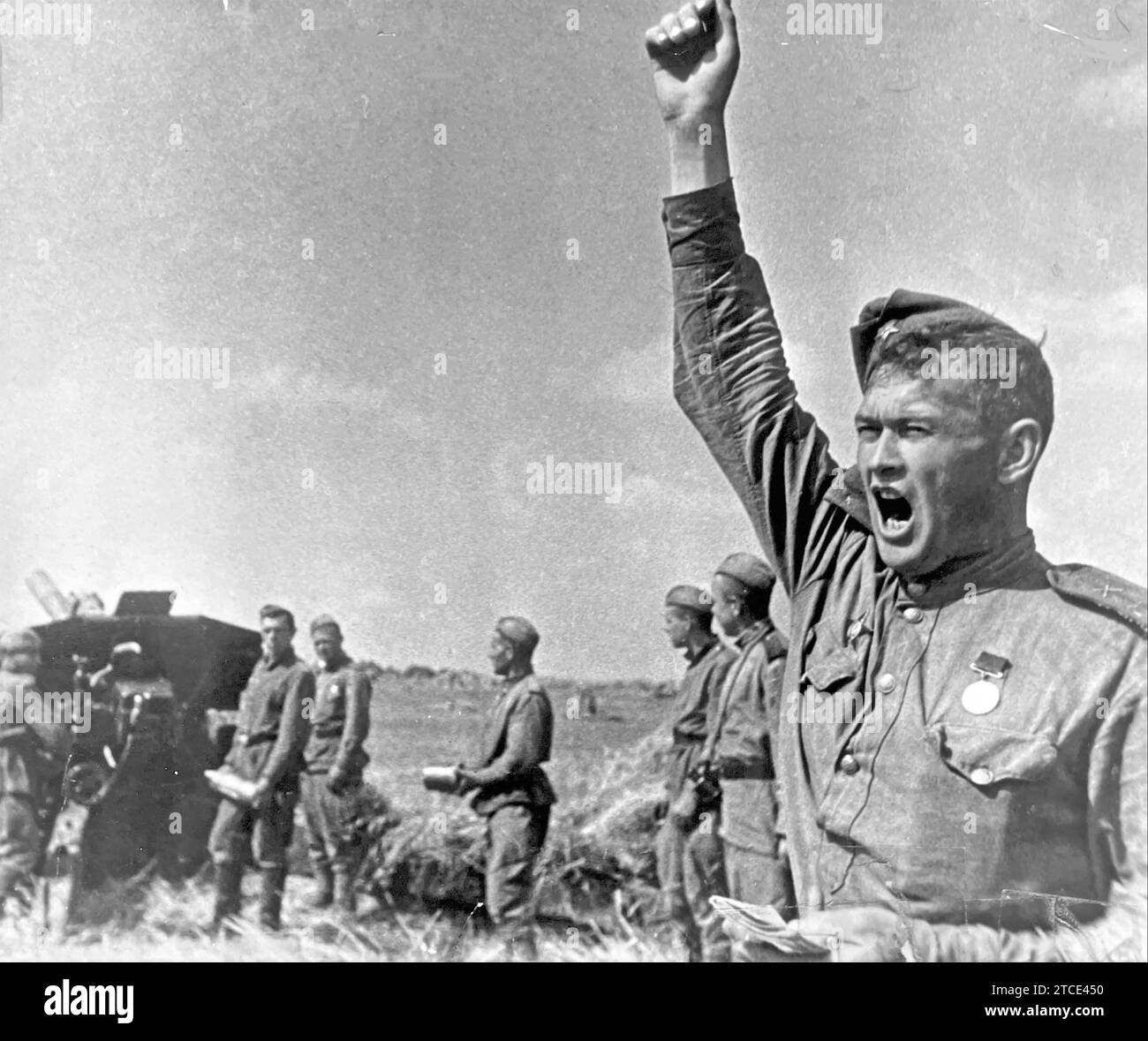 Der ROTE ARMEEGEWEHR-Kommandant wird den Befehl geben, Feuer zu schießen, während seine Truppe mit weiteren Granaten bereit steht, etwa 1943. Stooks of Weizen stehen auf offenen Feldern im Hintergrund. Stockfoto
