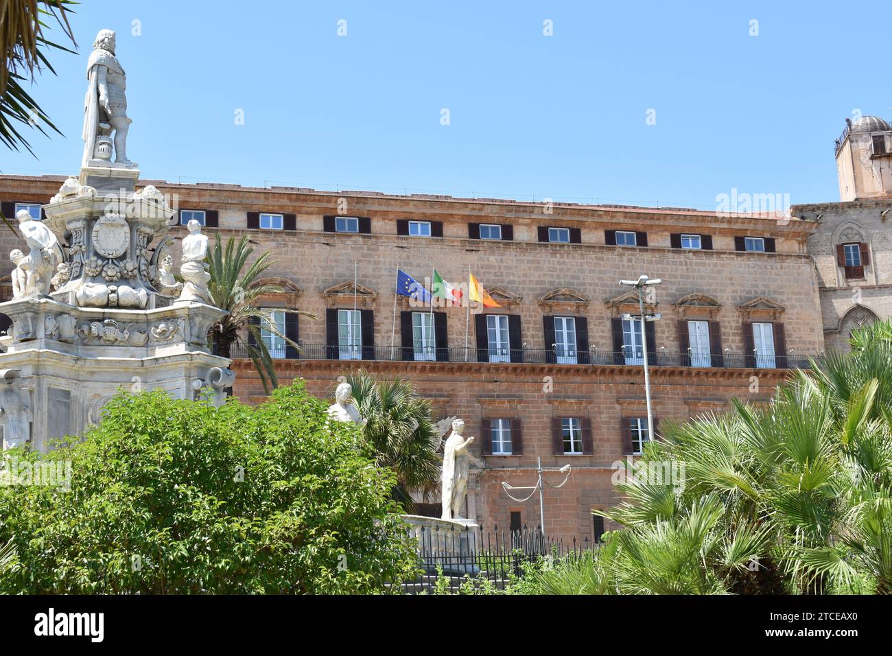 Europäische, italienische und sizilianische Flagge winkt nebeneinander im Wind auf der Außenseite des Palazzo dei Normanni Gebäudes Stockfoto