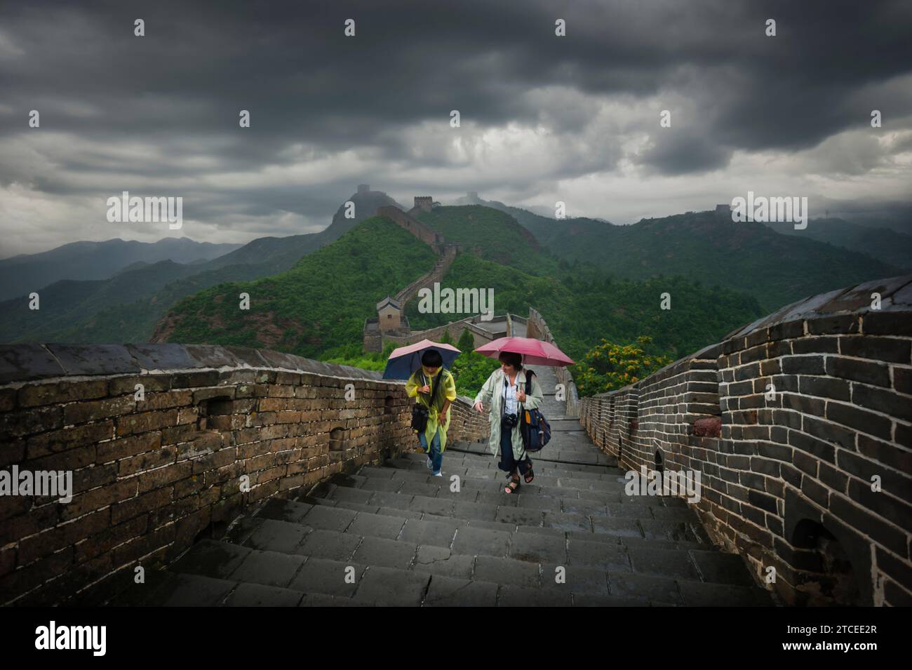 Reiseleiter und Reiseleiter an einem nassen und stimmungsvollen Tag auf der Chinesischen Mauer im Jinshanling Luanping County, Stockfoto