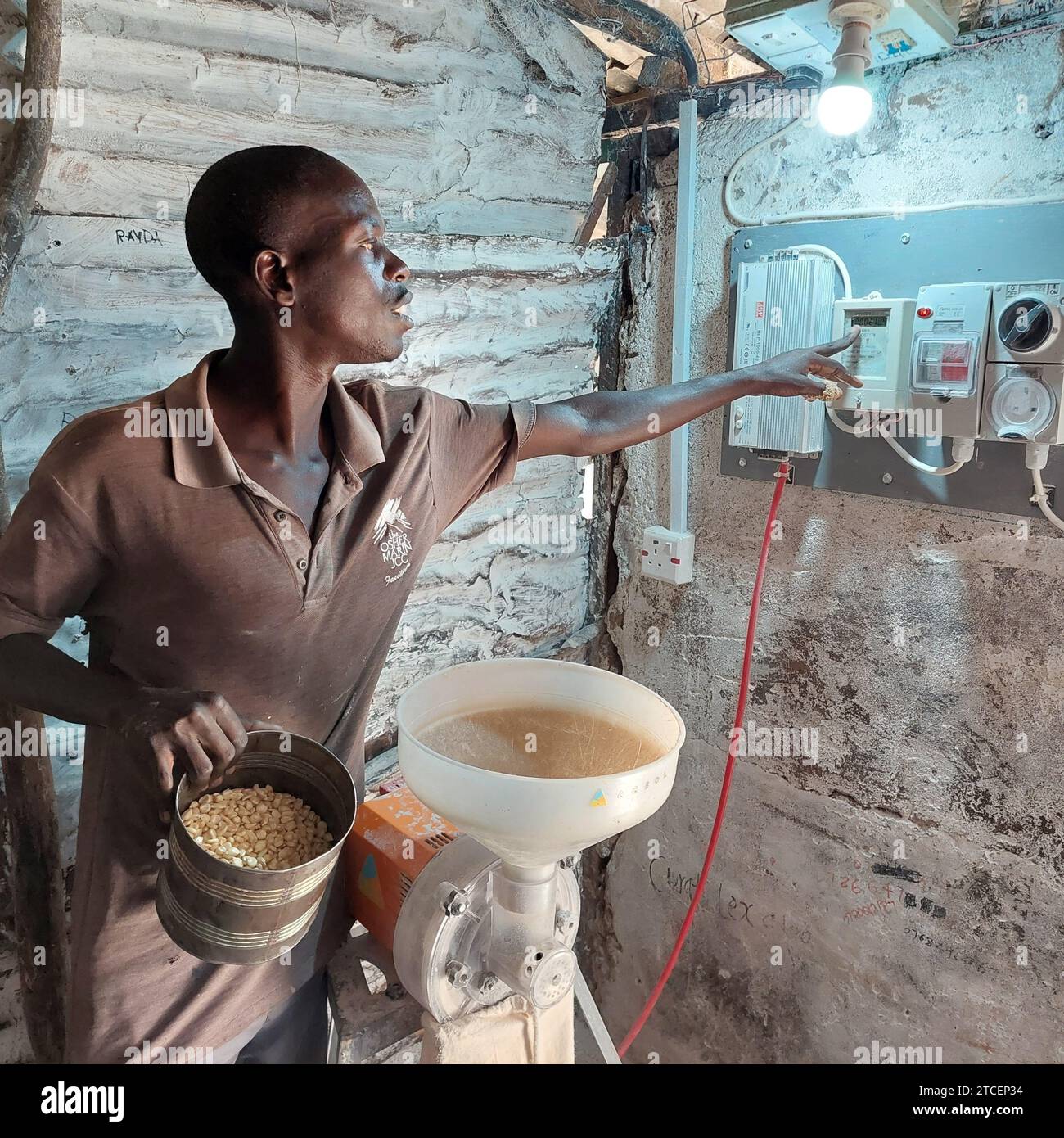 © PHOTOPQR/LE PARISIEN/frédéric Mouchon ; Ndeda ; 06/11/2023 ; Marvin Ochieng, meunier à Ndeda, Bénéficie dans la Case qui lui sert de boulangerie d'une Prise de courant reliée au réseau solaire de l'île, qui lui permet de moudre ses grains de mais pour fabriquer de la farine d'Ugali, un plat typique kenyan. Environnement, le Miracle kényan: Avec l'énergie solaire, le saut dans la modernité de l'île de Ndeda Sur le lac Victoria (Kenia), l'île de Ndeda EST passée depuis cinq ans du charbon de bois et de la lampe à pétrole à l'électricité d'origine solaire. UN saut dans la modernité pour ses Stockfoto