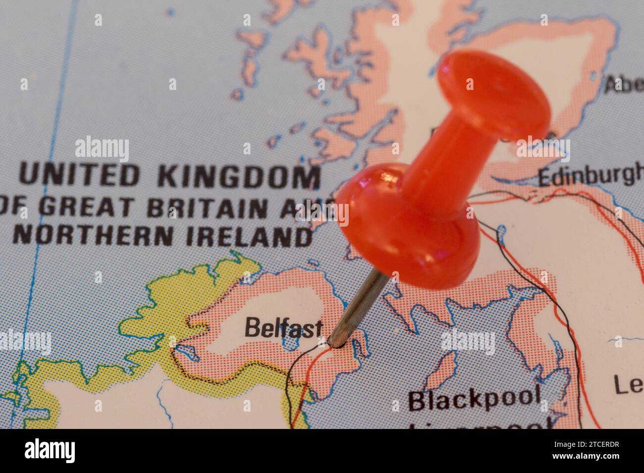 Ein roter Stift, der in eine Karte Westeuropas gesteckt wurde und den Standort von Belfast feststellte Stockfoto