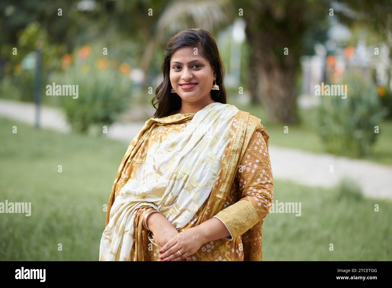 Porträt einer Indianerin im gelben Sari-Kleid, die an einer Hochzeit im Freien teilnimmt Stockfoto