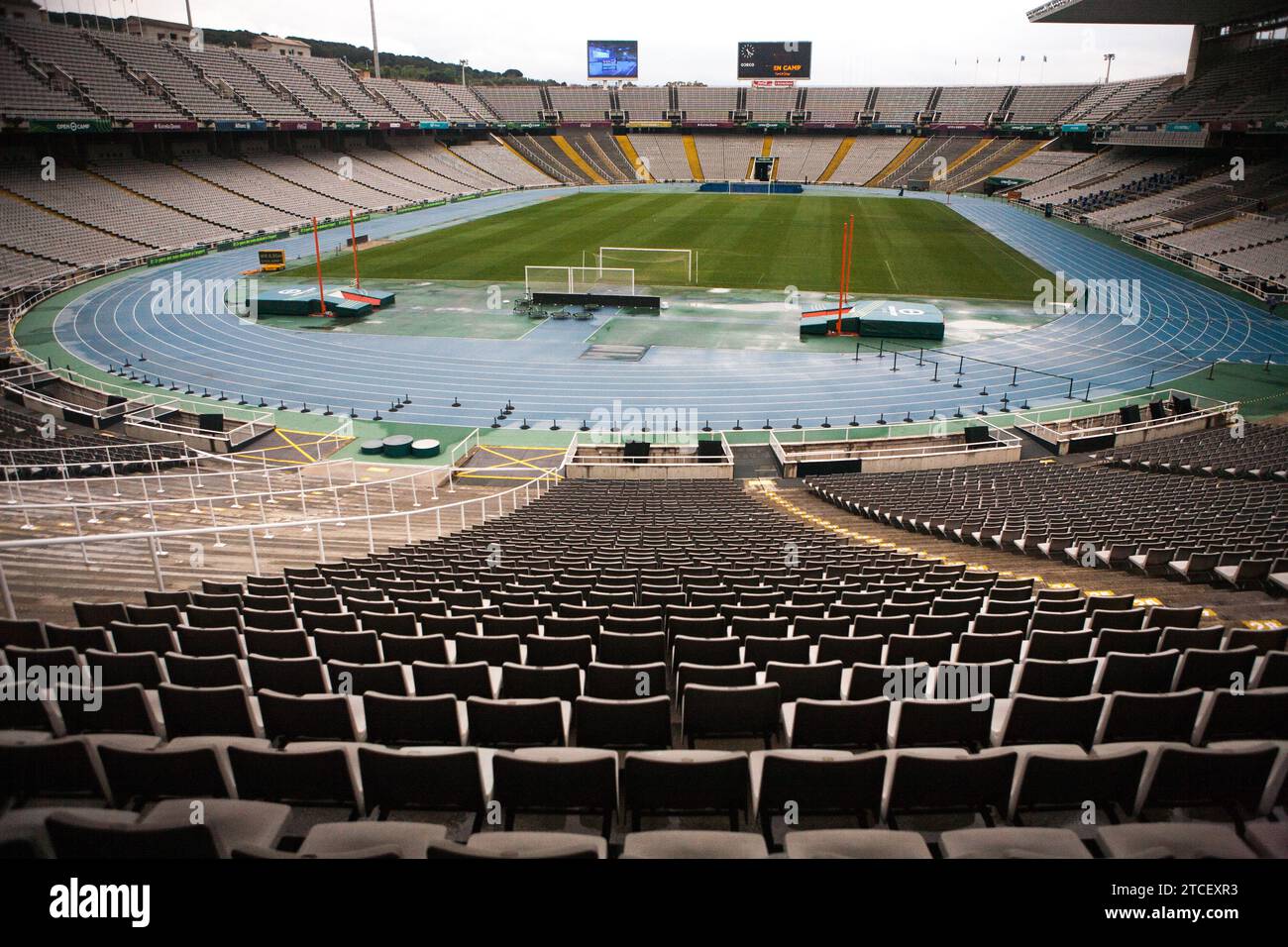 Das Bild zeigt ein großes, ovalförmiges Stadion mit einer Laufbahn, die das Feld umgibt. Die Stände sind mit leeren Sitzreihen gefüllt Stockfoto