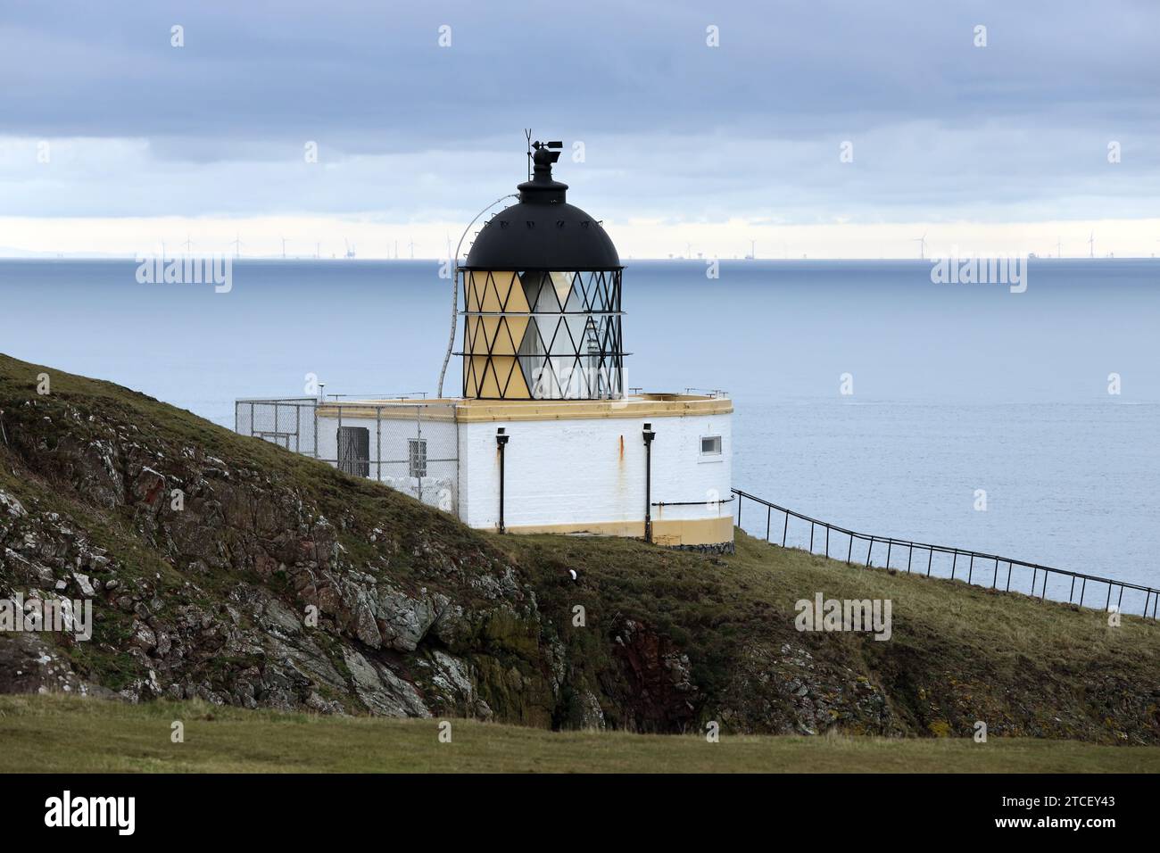 St Abbs Head Lighthouse, mit Windturbinen im Hintergrund, St Abbs, Berwickshire, Schottland, Großbritannien Stockfoto