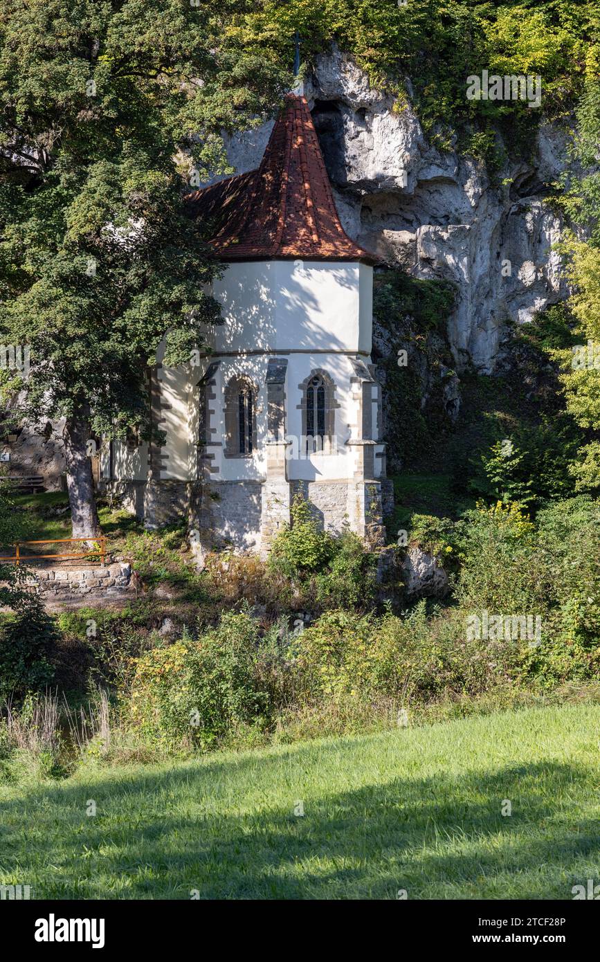 Alte Wallfahrtskirche St. Wendel am Stein direkt am Berg mit Bäumen im Sommer Stockfoto