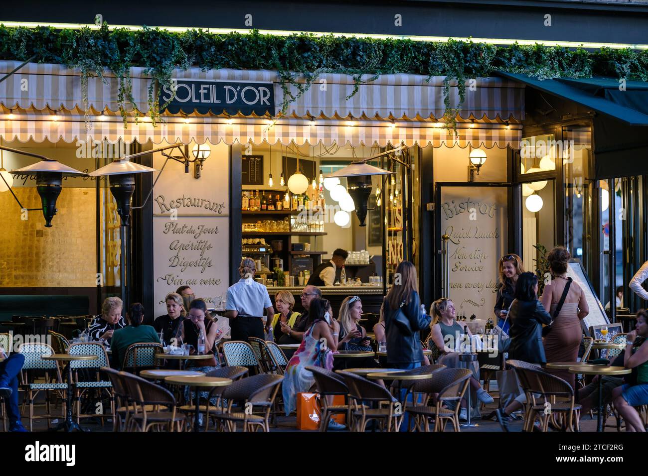 Paris, Frankreich - 8. Oktober 2023 : Blick auf die Menschen, die draußen sitzen und in einem Restaurant-Bistro in Paris Frankreich Abendessen und Getränke genießen Stockfoto