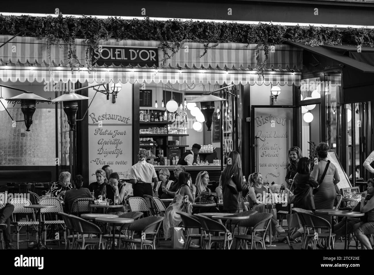 Paris, Frankreich - 8. Oktober 2023 : Blick auf die Menschen, die draußen sitzen und in einem Restaurant-Bistro in Paris Frankreich Abendessen und Getränke genießen Stockfoto