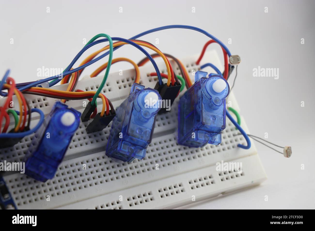 Leichte Mikroservos mit Kunststoffgetriebe, die an die Steckplatine angeschlossen sind. Konzeptdemonstration elektronischer Projekte mit Grundkomponenten Stockfoto