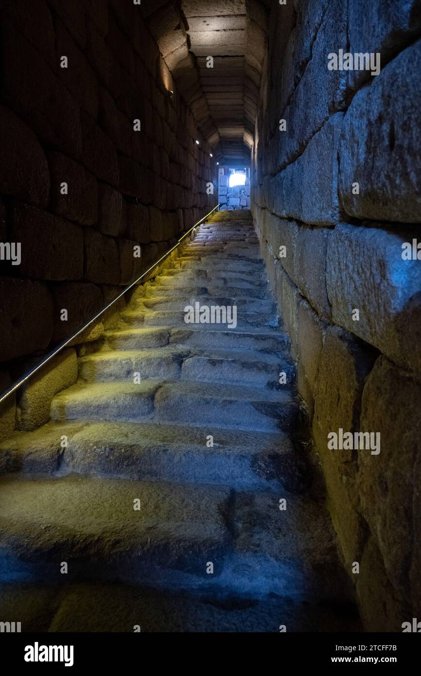 Alte Steintreppe, die zum Wasser führte, führte zu einem hellen Ausgang in einem schwach beleuchteten Tunnel, der Hoffnung und Richtung symbolisiert. Stockfoto