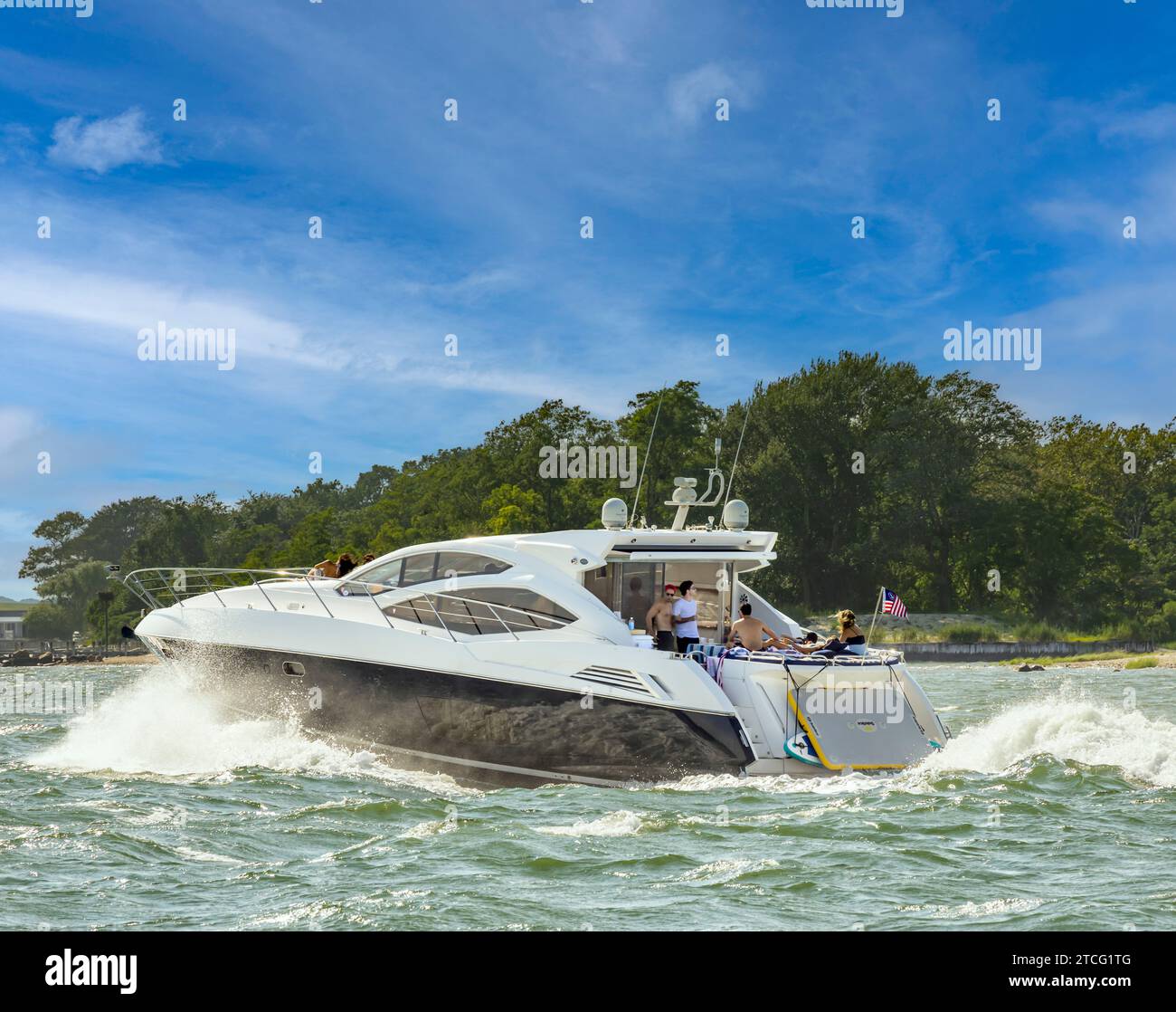 Große Motoryacht, die durch das Wasser pflügt und Passagiere Spaß haben Stockfoto