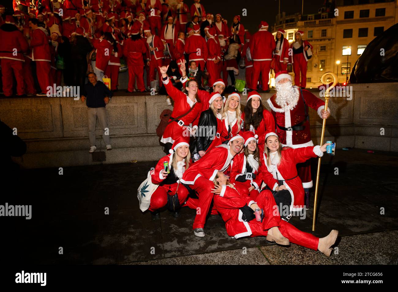 Die Leute nehmen an der SantaCon am Trafalgar Square Teil, bei der sie sich als Weihnachtsmann verkleiden und dann in die Stadt gehen, um Weihnachtsstimmung zu verbreiten. Die Stockfoto