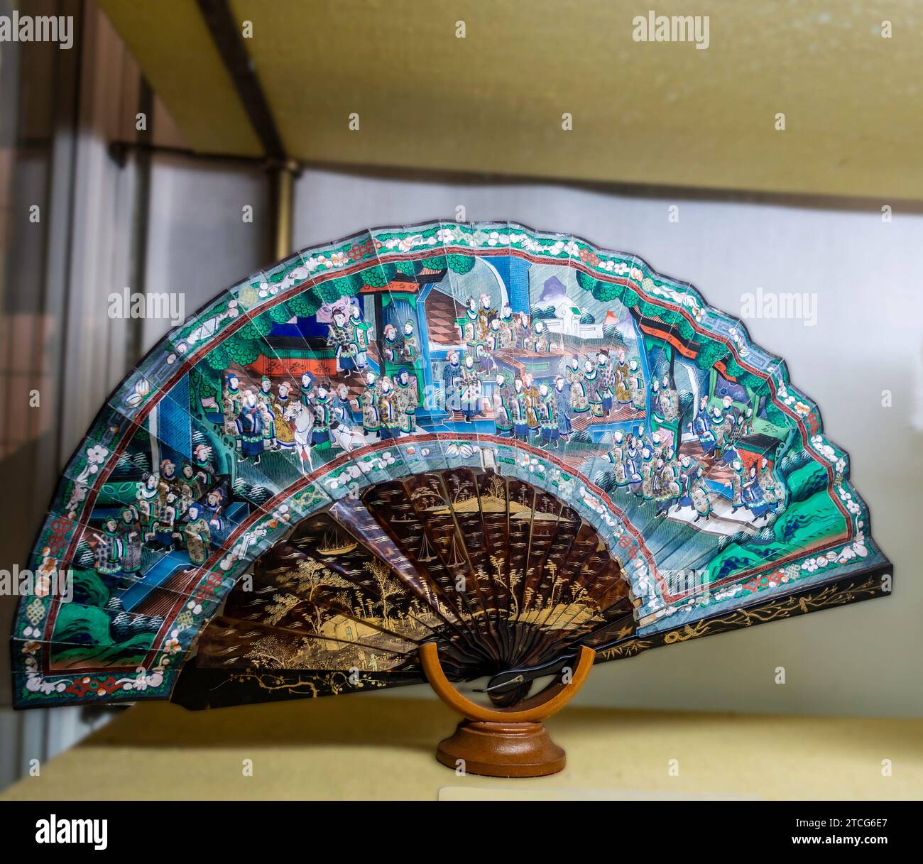 Farbenfroher Handfan mit detaillierten asiatischen Kunstwerken am Stand im Alcázar von Sevilla, dem Königlichen Palast von Sevilla, Spanien. Stockfoto