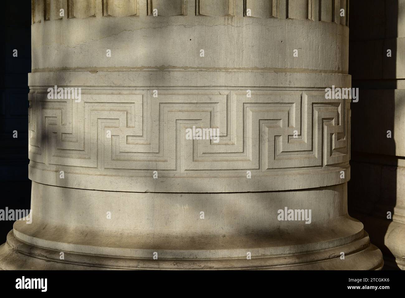 Griechisches geometrisches Mäander-Hakenkreuzmuster auf einer großen weißen Steinsäule Stockfoto