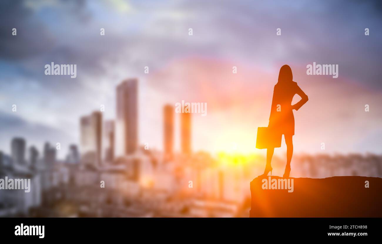 Silhouette Geschäftsfrau auf Sonnenuntergang Stadt Hintergrund. Selbstbewusste, starke, kluge Geschäftsfrau blickt auf Wolkenkratzer. Frauen bauen Karriere in der Wirtschaft auf, p Stockfoto