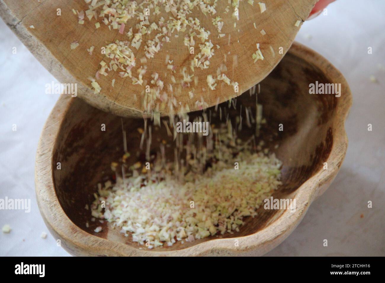 Eine Holzschale mit einem Sieb, das mit einer kleinen Menge Getreidekörner gefüllt ist. Stockfoto