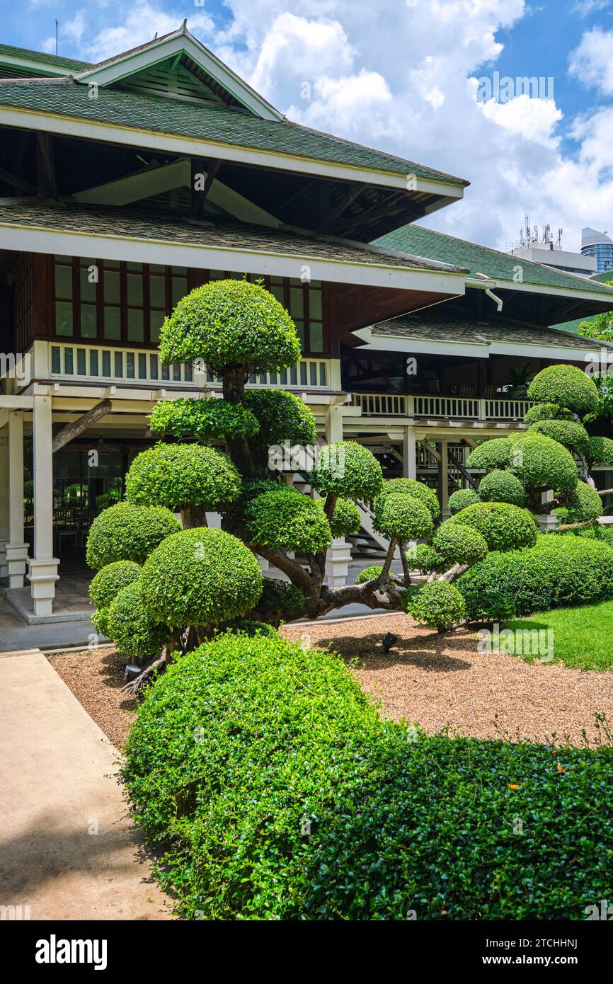Blick auf die Außenfassade mit aufwändiger Landschaftsgestaltung. Im Nai Lert Park Heritage Home in Bangkok, Thailand. Stockfoto