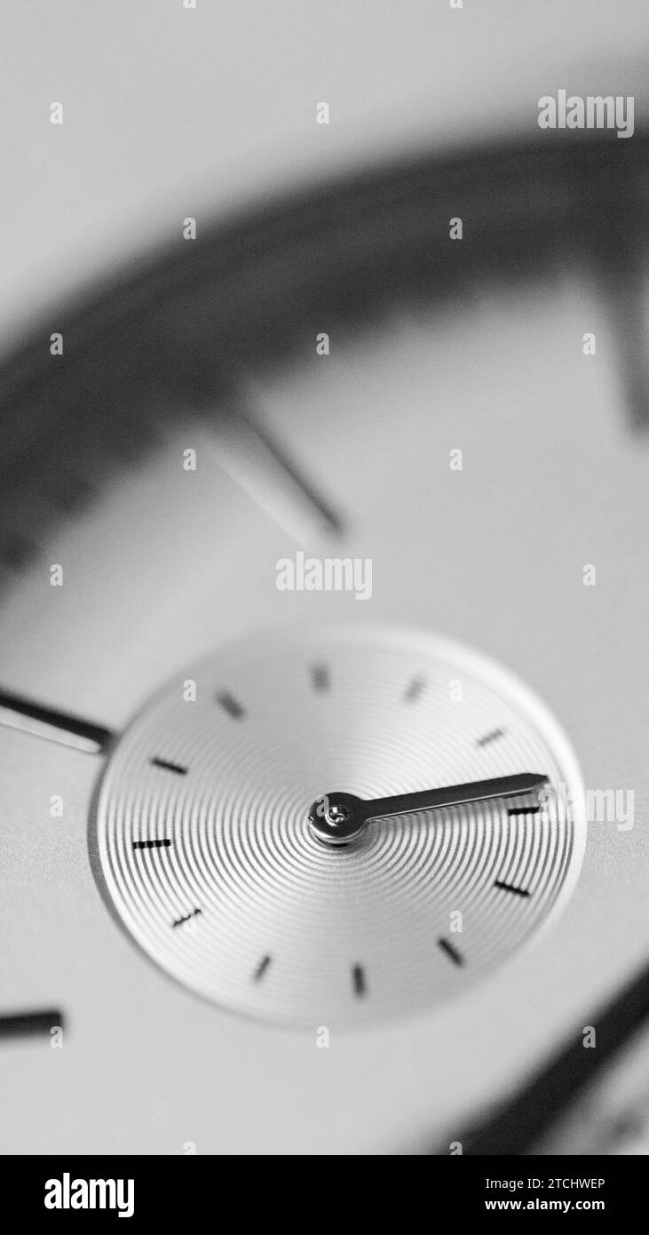 Eine vertikale Graustufenaufnahme mit Details auf einer luxuriösen silbernen Uhr Stockfoto