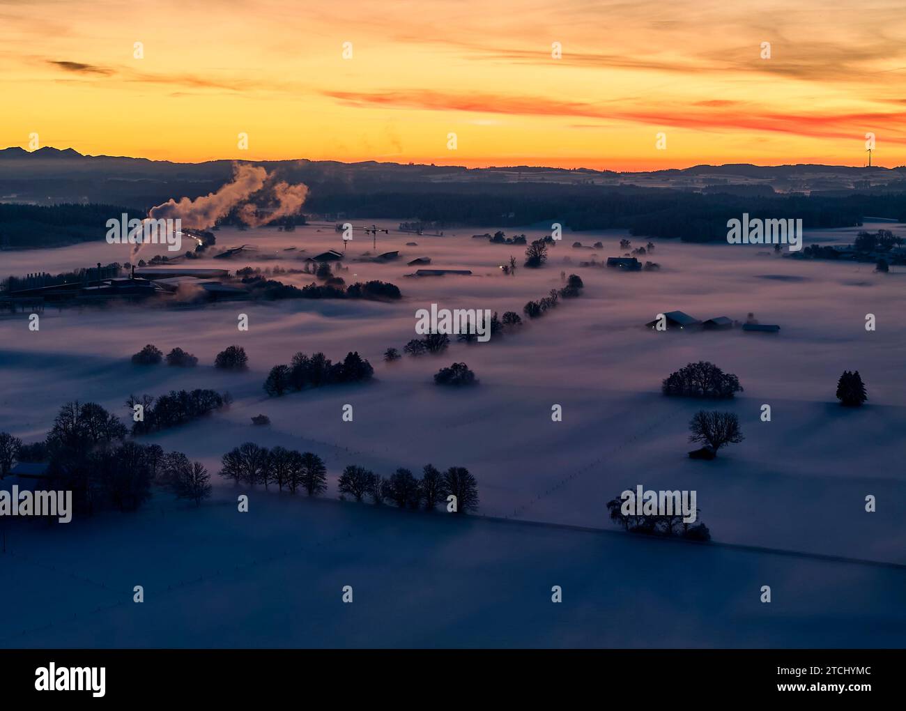 Drohnenfoto der bayerischen Landschaft mit Stadtblick, grüner Energieversorger Brennpunkt Energie GmbH mit Nebel am Abend kurz nach Sonnenuntergang in Marktoberdorf, Deutschland, 3. Dezember 2023. © Peter Schatz / Alamy Stock Photos Stockfoto