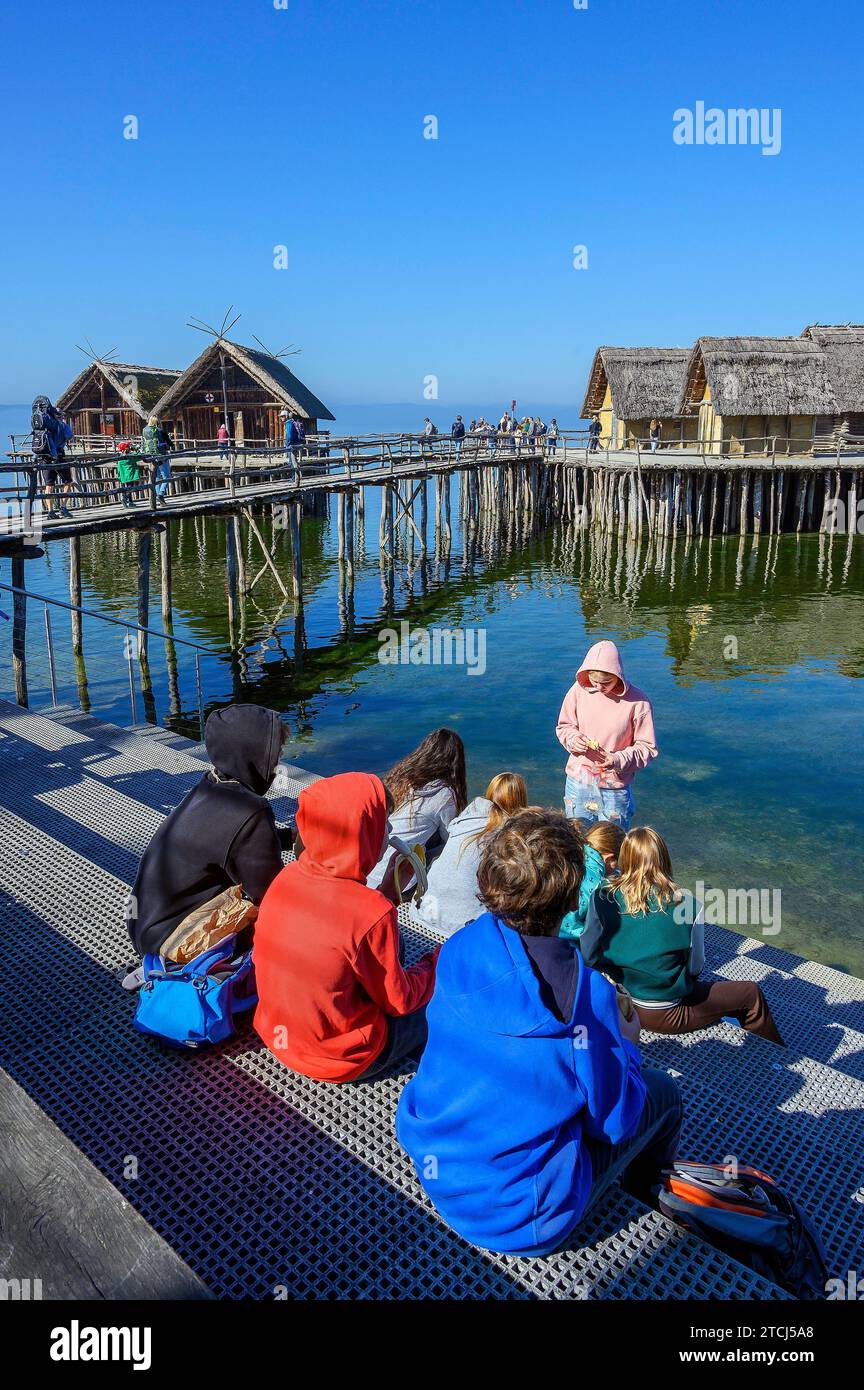 Touristen in den Pfahlbauten am Ufer des Bodensees, einer Touristenattraktion der Region und dem ältesten archäologischen Freilichtmuseum in Stockfoto