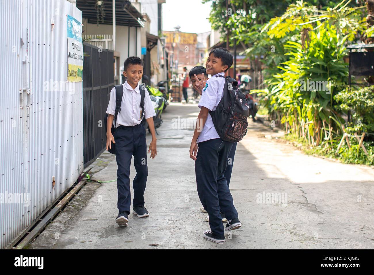 Bandung, Indonesien - 12. Dezember 2023: Drei unbekannte Jugendliche in Schuluniformen auf den Straßen von Bandung, Indonesien Stockfoto