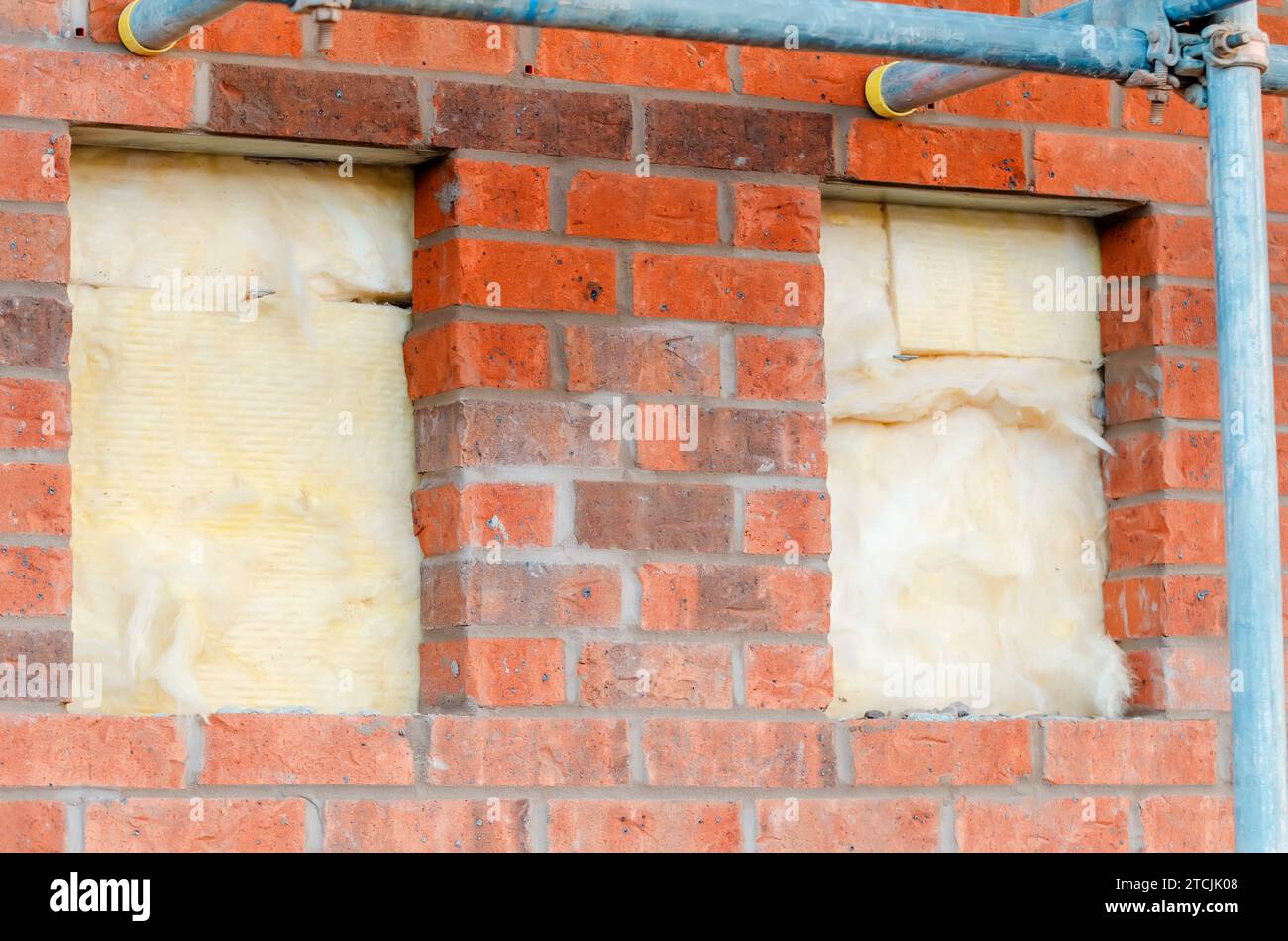 Dämmung der Wände von Neubauten durch Platzierung von Steinwolle in Wandhöhlen als Teil der Energiesparmaßnahmen Nahaufnahme. Haus isoliert mit mi Stockfoto