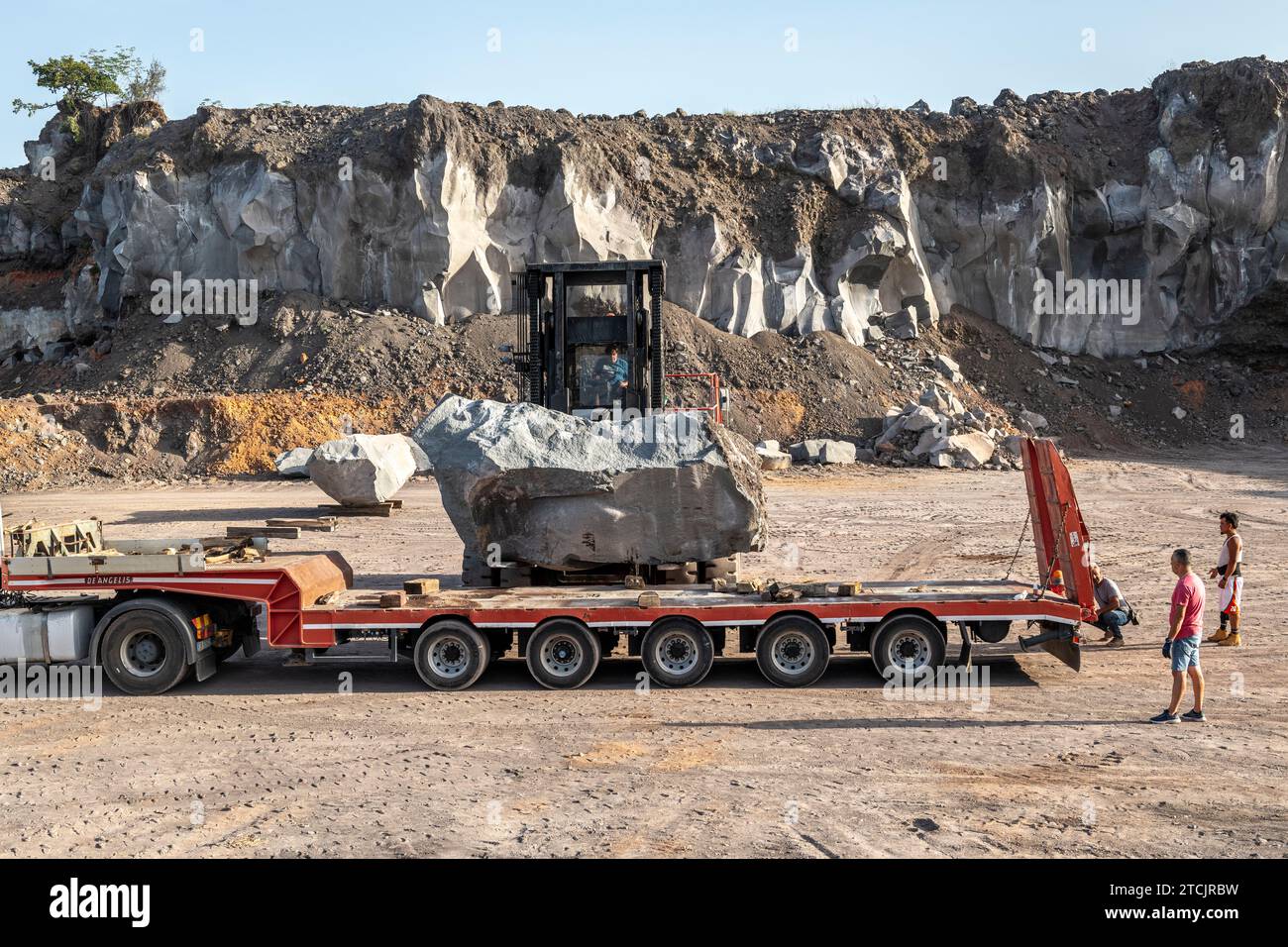 Gewinnung von vulkanischem Basaltgestein in einem Steinbruch an den Hängen des Ätna auf Sizilien. Riesige Platten werden vorsichtig geladen, bevor sie entfernt und zugeschnitten werden Stockfoto