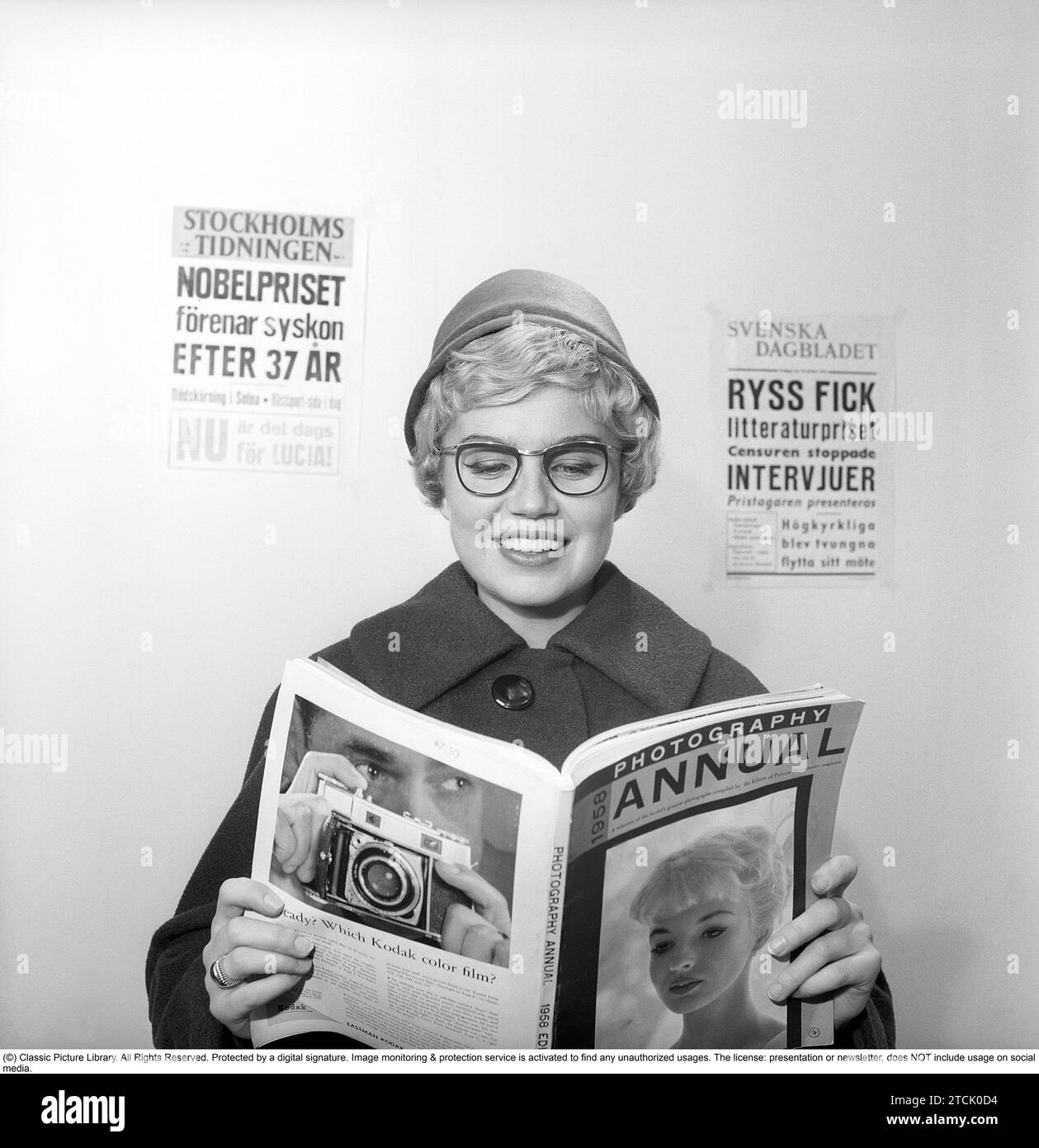 In den 1950er Jahren A Woman liest aus der Ausgabe 1958 von Photography Year, einer jährlichen Zusammenstellung einer Auswahl der besten Fotografien der Welt, die von den Herausgebern der Zeitschrift Popular Photography erstellt wurde. Schweden 1958. Kristoffersson Ref. CB95-11 Stockfoto