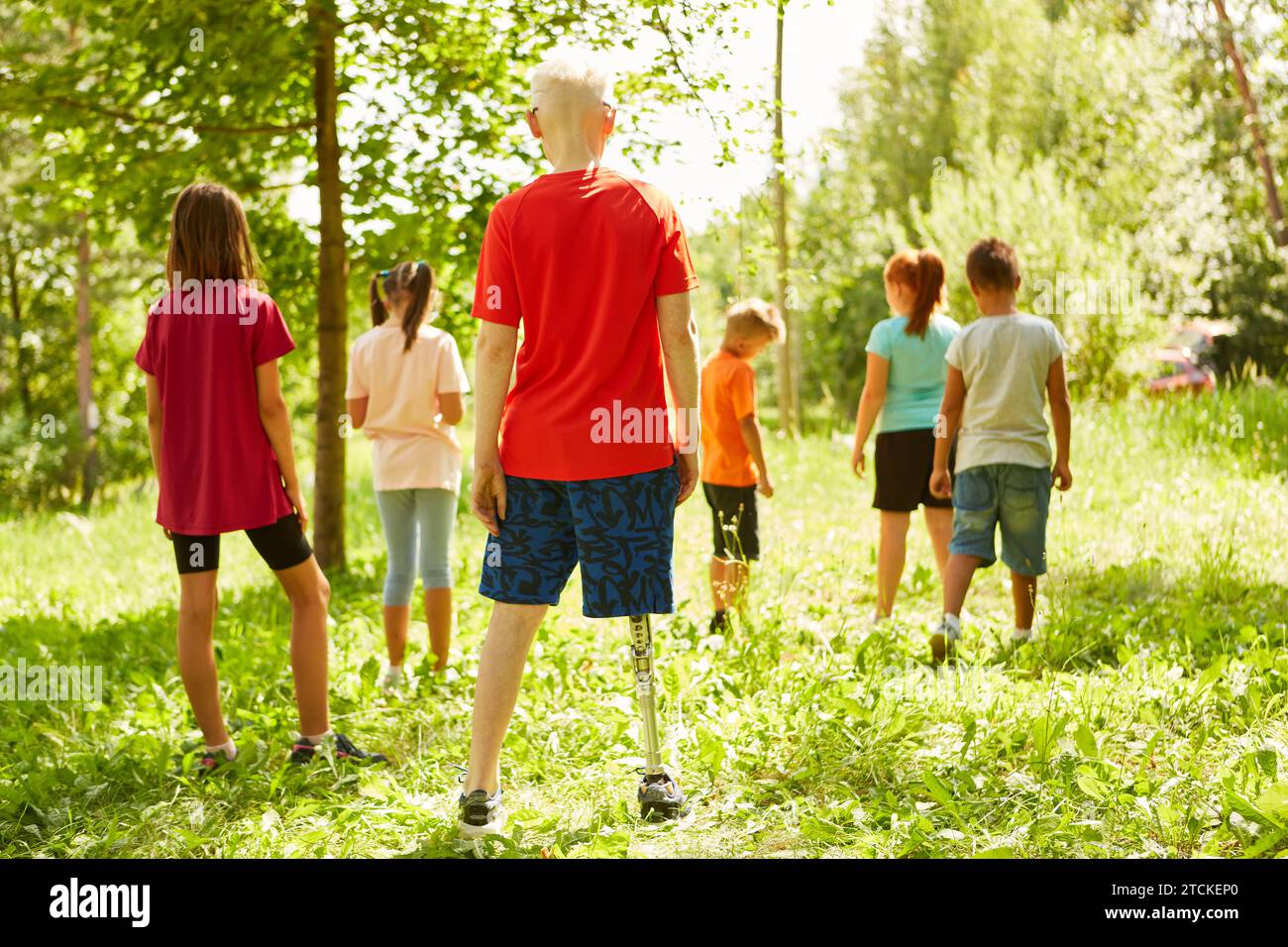 Rückansicht eines behinderten Jungen, der mit Freunden im Park steht Stockfoto