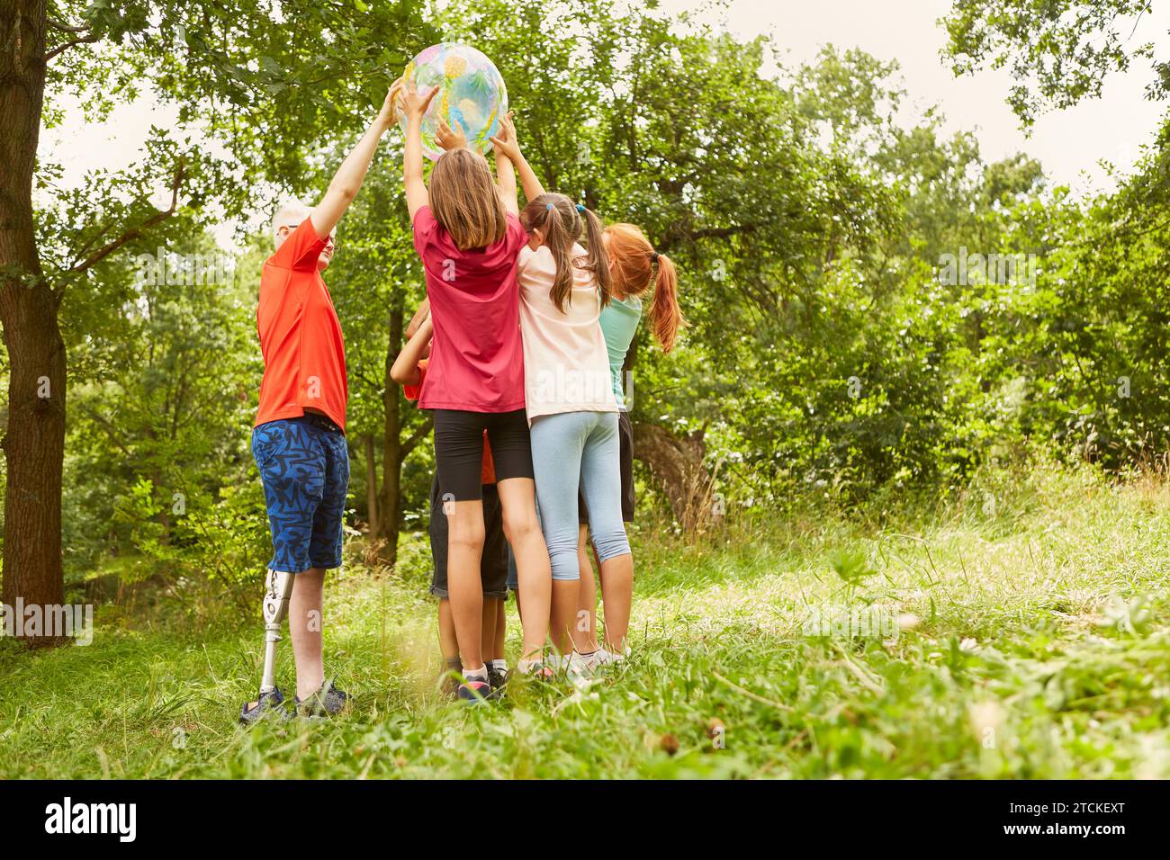 Spielerische Kinder genießen gemeinsam mit dem Ball im Park Stockfoto