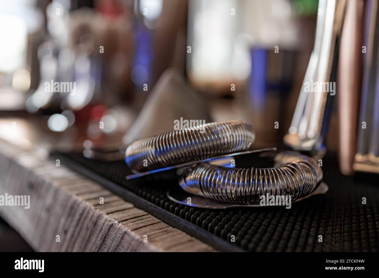 Metall, Chrom, Bar Cocktail Sieb, sitzt auf einer Bar mit verschwommenem Hintergrund. Stockfoto