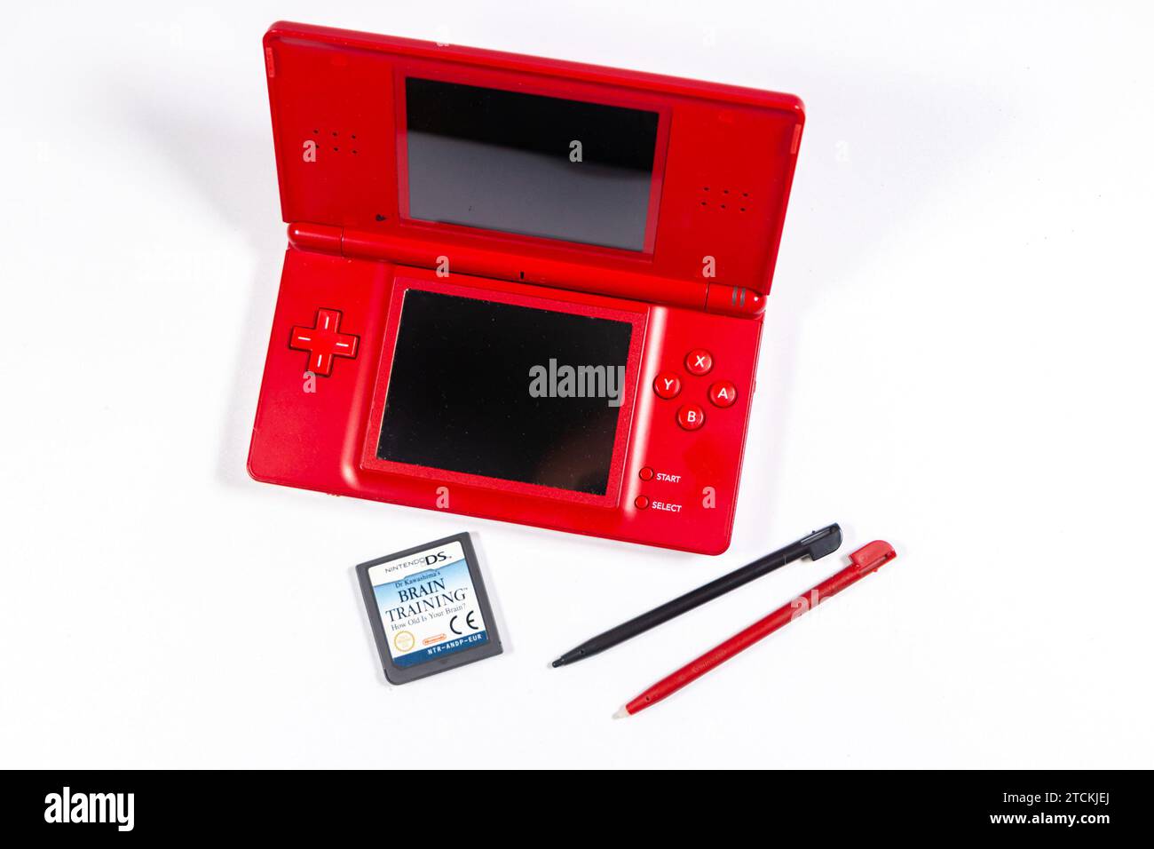 Roter Vintage-Kunststoff Nintendo DS Lite tragbare Spielkonsole isoliert auf Studiohintergrund mit Zubehör und Karte Stockfoto