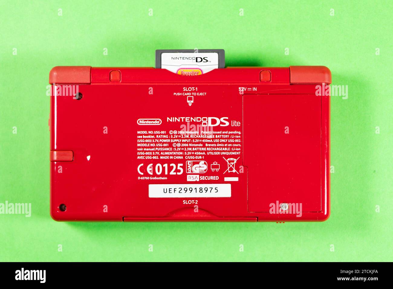 Rote tragbare Nintendo DS Lite-Spielkonsole aus Kunststoff isoliert auf Studiohintergrund mit Zubehör und Karte Stockfoto