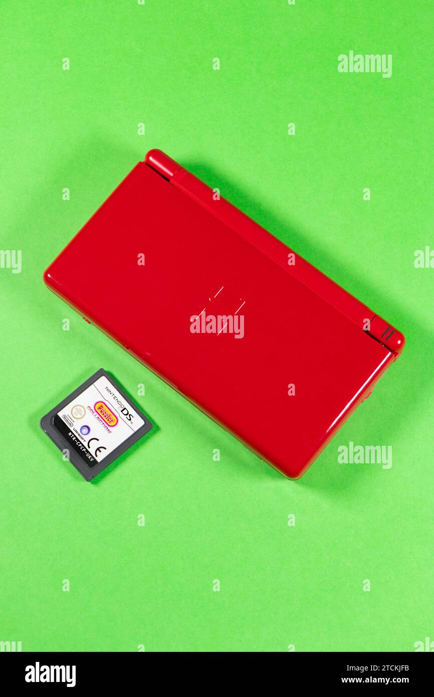 Rote tragbare Nintendo DS Lite-Spielkonsole aus Kunststoff isoliert auf Studiohintergrund mit Zubehör und Karte Stockfoto