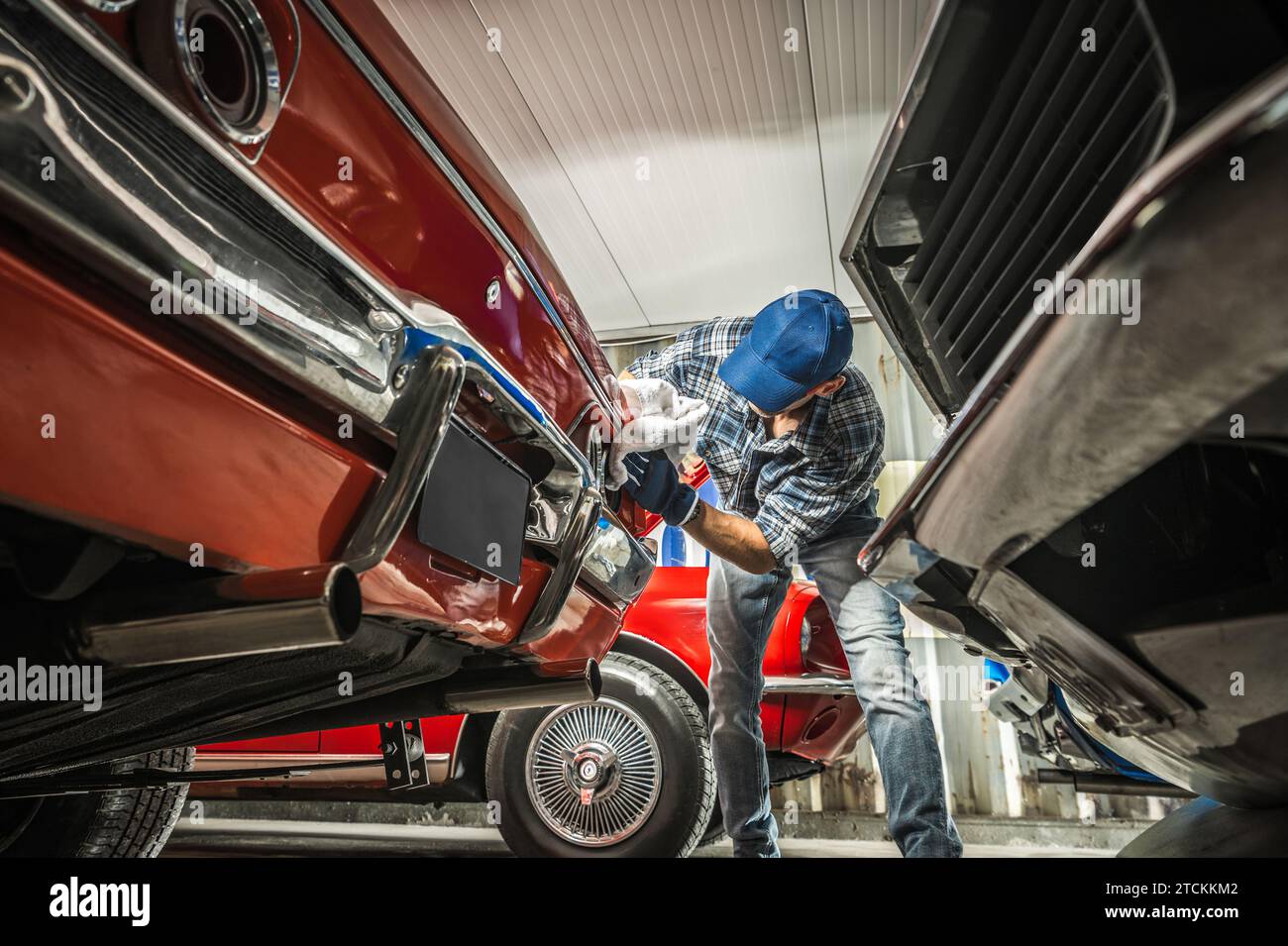 Kaukasischer Oldtimer-Sammler reinigt sein Fahrzeug in einem Lagerhaus Stockfoto