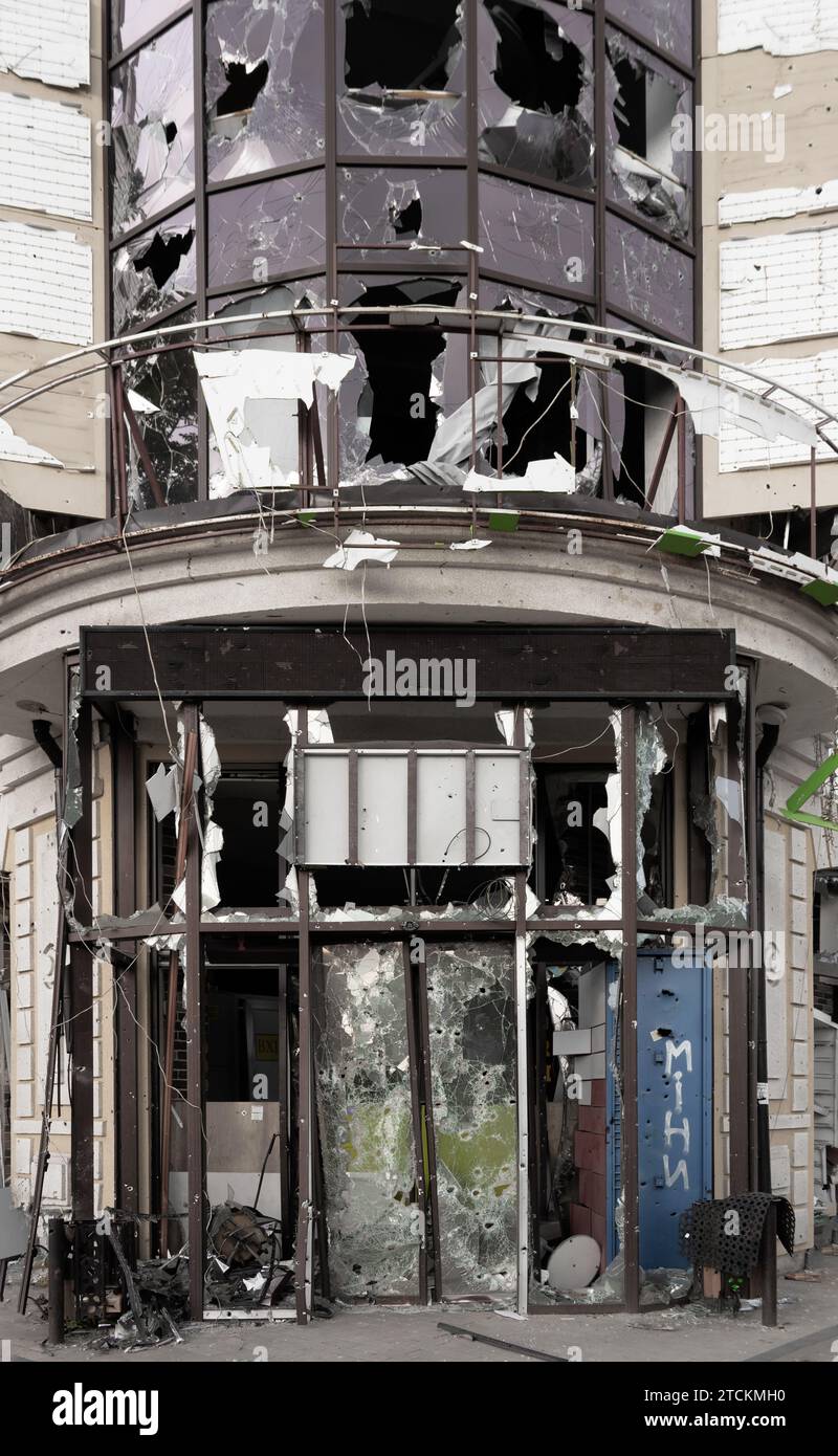 Zerstörter Supermarkt. Die Fassade des Gebäudes mit Löchern von Kugeln und Schrapnell. Krieg in der Ukraine. Stockfoto