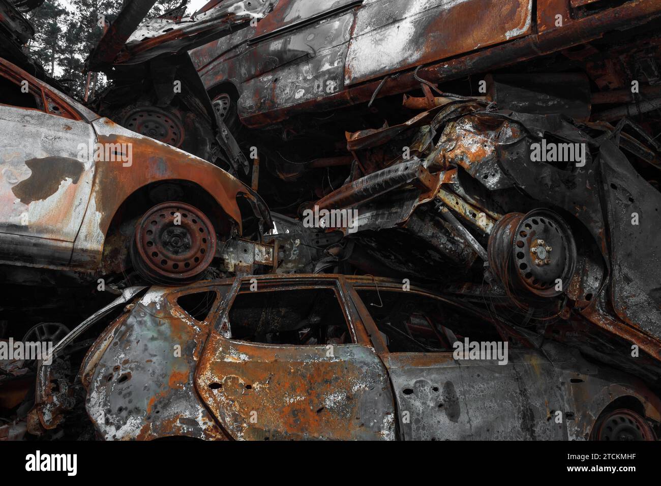 Eine Müllhalde von abgeschossenen und verbrannten Autos als Folge der russischen Invasion in die Ukraine. Krieg in der Ukraine. Stockfoto