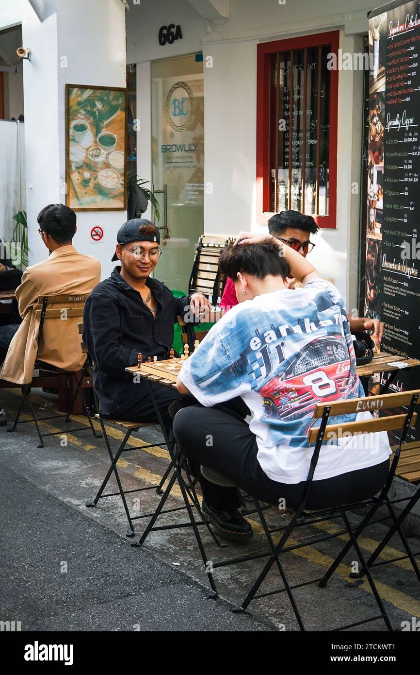 Eine vielfältige Gruppe von Menschen, die gemeinsam vor einem Restaurant essen Stockfoto