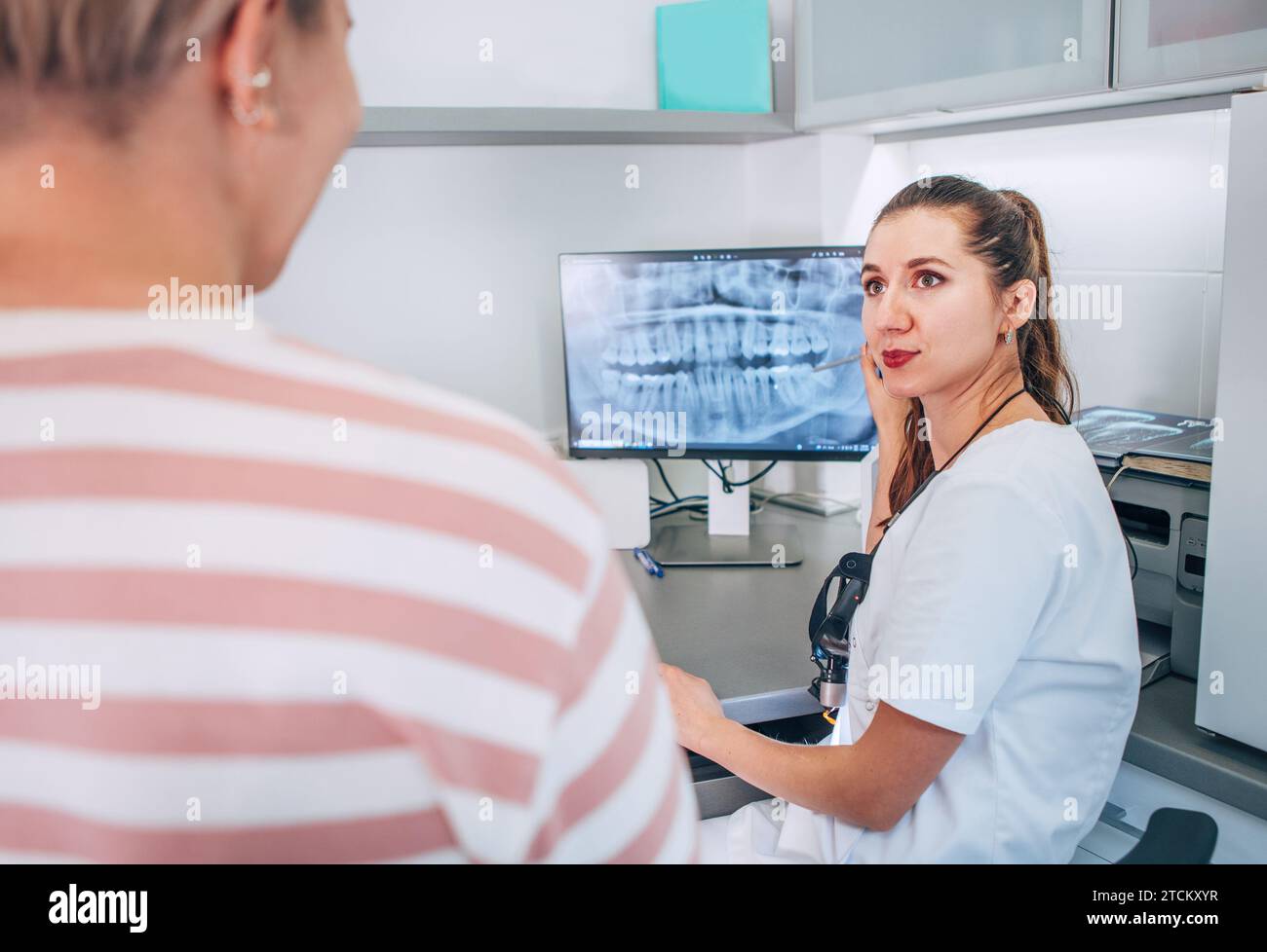 Zahnarztin in Uniform mit intraoraler 3D-Röntgenaufnahme des Patienten auf PC-Bildschirm. Zahnärztlicher Klinikpatient besucht moderne medizinische Station. Hea Stockfoto